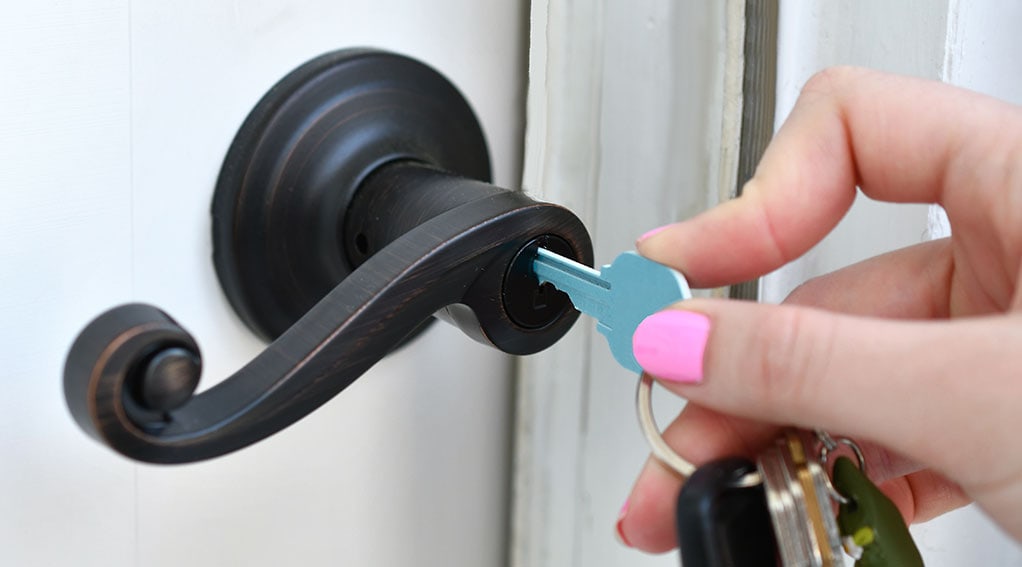 Photo of a person putting a key in a lock